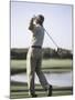 Rear View of a Senior Man Swinging a Golf Club-null-Mounted Photographic Print