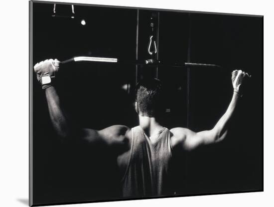 Rear View of a Young Man Exercise on a Lateral Pull-Down Weight Machine-null-Mounted Premium Photographic Print