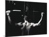 Rear View of a Young Man Exercise on a Lateral Pull-Down Weight Machine-null-Mounted Photographic Print