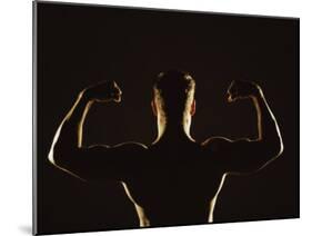 Rear View of a Young Man Flexing His Muscles-null-Mounted Photographic Print