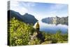 Rear view of photographer admiring the Mefjord blue water standing on rocks-Roberto Moiola-Stretched Canvas