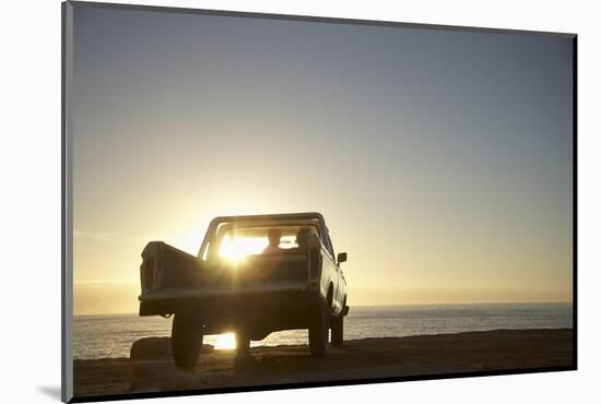 Rear View of Young Couple in Pick-Up Truck Parked in Front of Ocean Enjoying Sunset-Nosnibor137-Mounted Photographic Print