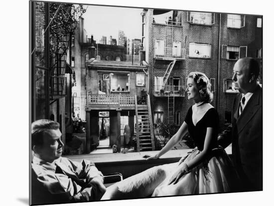 REAR WINDOW, 1954 directed byALFRED HITCHCOCK On the set, Grace Kelly between James Stewart and Alf-null-Mounted Photo