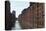 Red Brick Warehouses Overlook a Canal in the Speicherstadt District-Stuart Forster-Stretched Canvas