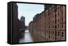 Red Brick Warehouses Overlook a Canal in the Speicherstadt District-Stuart Forster-Framed Stretched Canvas