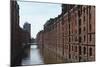 Red Brick Warehouses Overlook a Canal in the Speicherstadt District-Stuart Forster-Mounted Photographic Print
