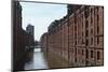 Red Brick Warehouses Overlook a Canal in the Speicherstadt District-Stuart Forster-Mounted Photographic Print