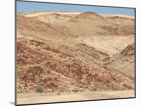 Red Rocky Landscape with Jeep in Distance, Purros Conservancy Wilderness, Kaokoland, Namibia-Kim Walker-Mounted Photographic Print