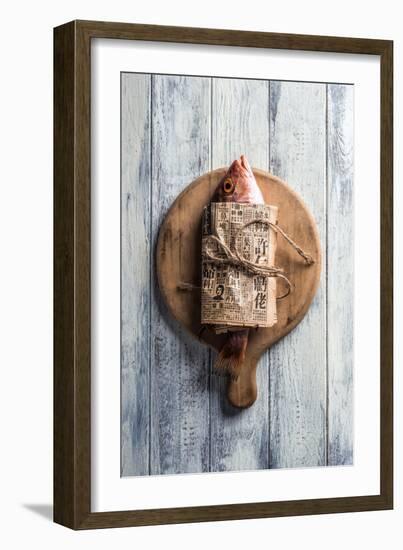 Red Snapper Wrapped in Chinese Newspaper on Wooden Background-Gary Jones-Framed Photographic Print