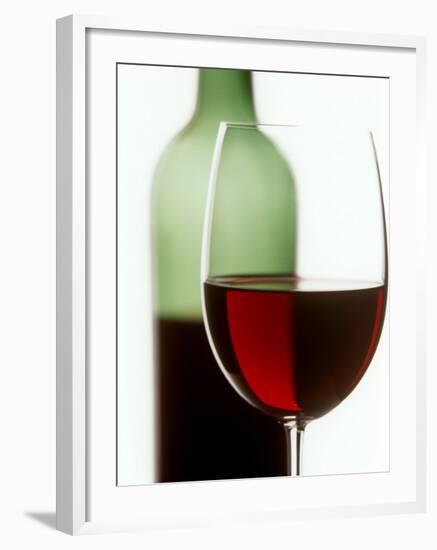Red Wine Glass with Half-Full Wine Bottle in Background-Joerg Lehmann-Framed Photographic Print