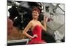 Redhead Pin-Up Girl in 1940's Style Dancer Attire Holding on to a Vintage Aircraft Propeller-null-Mounted Photographic Print