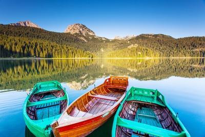 https://imgc.allpostersimages.com/img/posters/reflection-in-water-of-mountain-lakes-and-boats_u-L-Q1K93UZ0.jpg?artPerspective=n