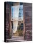 Reflection of the windmill and tractor in the window of an old building in ghost town.-Julie Eggers-Stretched Canvas