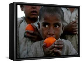 Refugee Boys Eat Tangerines at a Small Refugee Camp-null-Framed Stretched Canvas