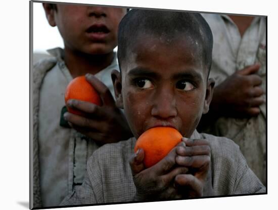 Refugee Boys Eat Tangerines at a Small Refugee Camp-null-Mounted Photographic Print