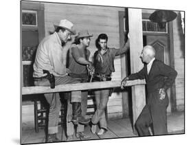 RIO BRAVO, 1959 directed by HOWARD HAWKS On the set, John Wayne, Dean Martin and Ricky Nelson with -null-Mounted Photo