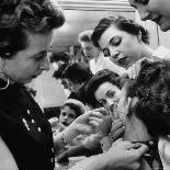 Woman Piercing Another Woman's Ears as Friends Look On-Robert W^ Kelley-Photographic Print