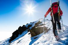 Mountaineer Walking up along a Snowy Ridge with the Skis in the Backpack. in Background a Shiny Bri-Roberto Caucino-Framed Photographic Print