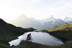 Mountain biker riding downhill at Bachalpsee lake at dawn, Grindelwald, Bernese Oberland-Roberto Moiola-Photographic Print