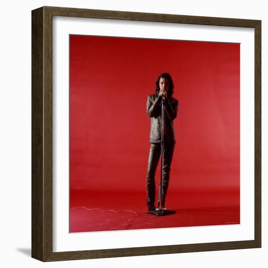 Rock Star Jim Morrison of the Doors Holding Microphone Alone as He Stands Against a Red Backdrop-Yale Joel-Framed Premium Photographic Print