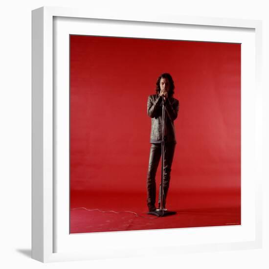 Rock Star Jim Morrison of the Doors Holding Microphone Alone as He Stands Against a Red Backdrop-Yale Joel-Framed Premium Photographic Print