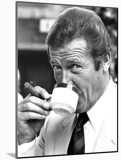 Roger Moore Drinking Coffee-Associated Newspapers-Mounted Photo