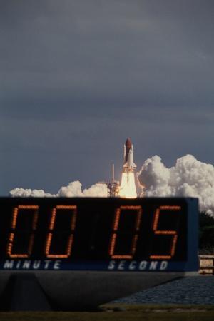 Space Shuttle Discovery Lifting Off and Countdown Clock