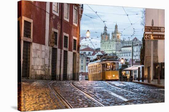 Romantic Atmosphere in Old Streets of Alfama with Castle in Background and Tram Number 28-Roberto Moiola-Stretched Canvas