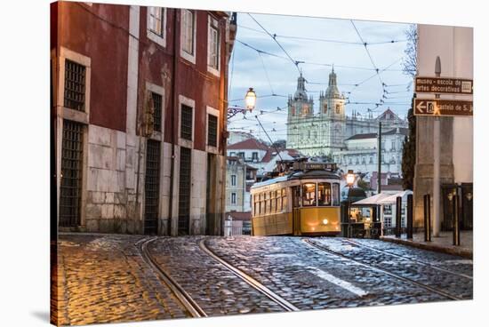 Romantic Atmosphere in Old Streets of Alfama with Castle in Background and Tram Number 28-Roberto Moiola-Stretched Canvas