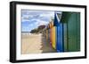 Row of Colourful Beach Huts and their Shadows, Distant Surfers in Sea, West Cliff Beach-Eleanor Scriven-Framed Photographic Print