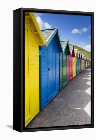 Row of Colourful Beach Huts and their Shadows with Green Hill Backdrop-Eleanor Scriven-Framed Stretched Canvas