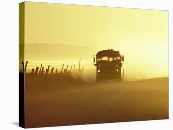 Rural School Bus Driving Along Dusty Country Road, Oregon, USA-William Sutton-Stretched Canvas