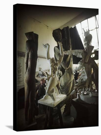 Russian Sculptor Ossip Zadkine Sitting in His Paris Studio Among Towering Sculptures-Gjon Mili-Stretched Canvas