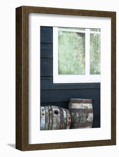 Rustic Barrels Lined Up Along an Old House Below a Window-Sheila Haddad-Framed Photographic Print