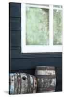 Rustic Barrels Lined Up Along an Old House Below a Window-Sheila Haddad-Stretched Canvas