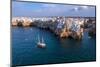 Sail boat anchored in the water off the white village of Polignano a Mare at sunset, Bari province-Paolo Graziosi-Mounted Photographic Print