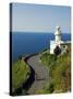 San Sebastian Bay Clifftop Lighthouse with Cyclist Riding Uphill-Christian Kober-Stretched Canvas