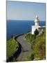 San Sebastian Bay Clifftop Lighthouse with Cyclist Riding Uphill-Christian Kober-Mounted Photographic Print