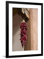 Santa Fe, New Mexico. Long, red chili, hanging from a wooden corbel and stucco wall-Jolly Sienda-Framed Photographic Print