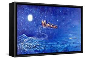 Santa in Night Sky over Winter Village in Sleigh Pulled by Reindeer-Bill Bell-Framed Stretched Canvas