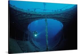 Scuba Diver Exploring a Shipwreck, Papua New Guinea, Coral Sea.-Reinhard Dirscherl-Stretched Canvas