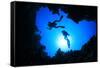 Scuba Divers Descend into an Underwater Cavern. Silhouettes against Sunburst-Rich Carey-Framed Stretched Canvas