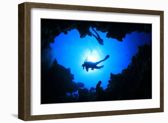 Scuba Divers Descend into an Underwater Cavern. Silhouettes against Sunburst-Rich Carey-Framed Photographic Print