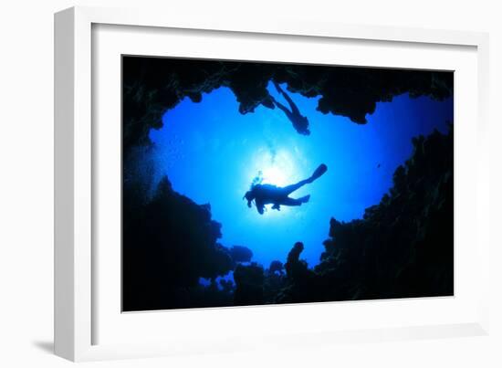 Scuba Divers Descend into an Underwater Cavern. Silhouettes against Sunburst-Rich Carey-Framed Photographic Print