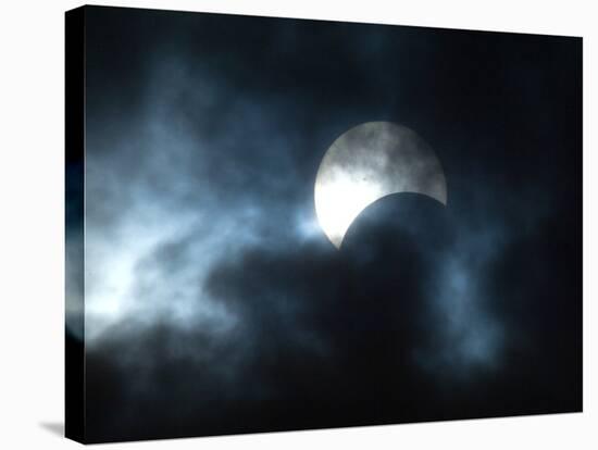 Seen Through Clouds the Sun is Partially Obscured by the Moon During an Eclipse-null-Stretched Canvas