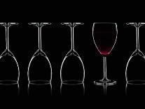 Row of Wine Glasses and a Glass of Red Wine Against a Black Background-Shawn Hempel-Laminated Photographic Print