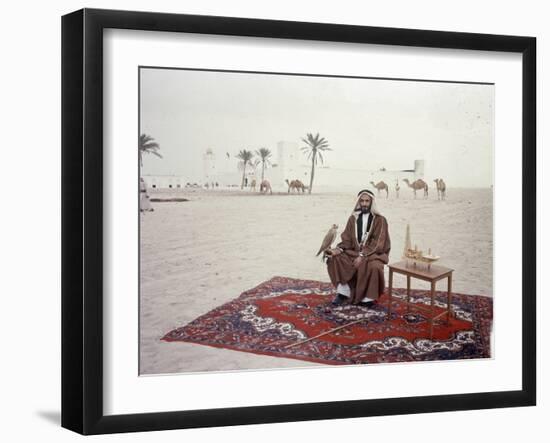 Sheikh Shakhbut Bin Sultan Al Nahyan Sitting in Front of His Palace Holding a Falcon, 1963-Ralph Crane-Framed Photographic Print