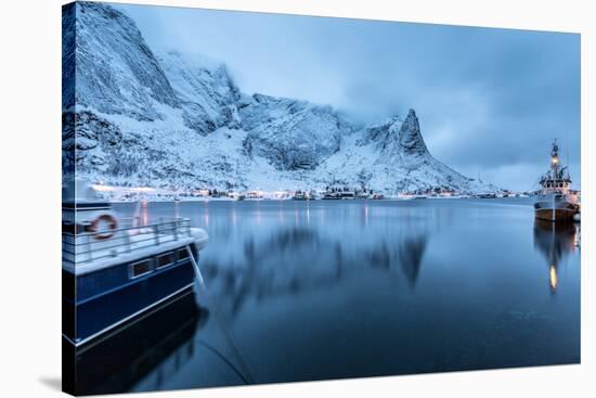 Ships Moored in the Small Harbor of Reine under a Gloomy Sky in the South of the Lofoten Islands-Roberto Moiola-Stretched Canvas