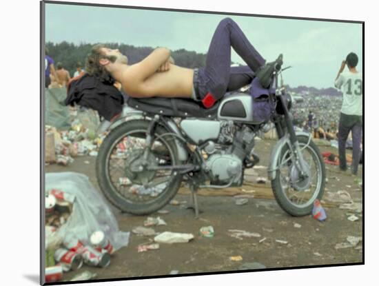 Shirtless Man in Levi Strauss Jeans Lying on Motorcycle Seat at Woodstock Music Festival-Bill Eppridge-Mounted Photographic Print