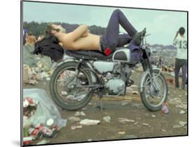 Shirtless Man in Levi Strauss Jeans Lying on Motorcycle Seat at Woodstock Music Festival-Bill Eppridge-Mounted Photographic Print